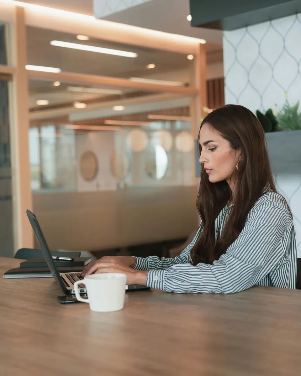 A professional working at a laptop in a modern office